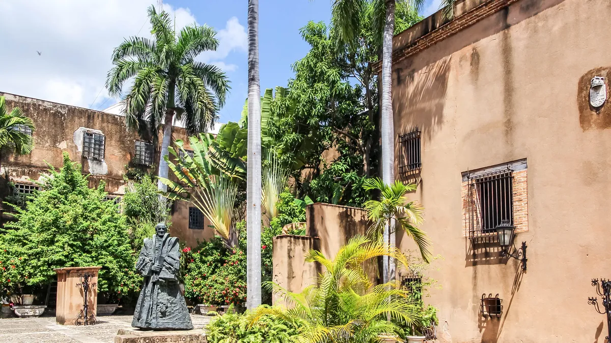 Palms and a bronze statue in the garden patio of the Museo de las Casas Reales