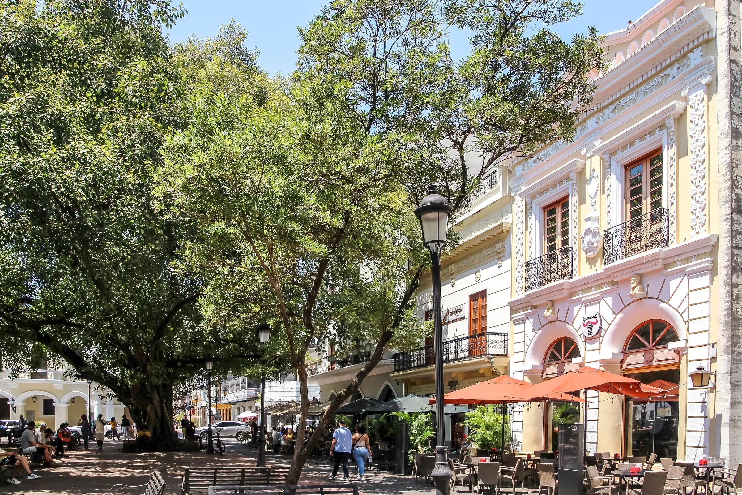 Parque Colón on a sunny day, with café tables under the trees